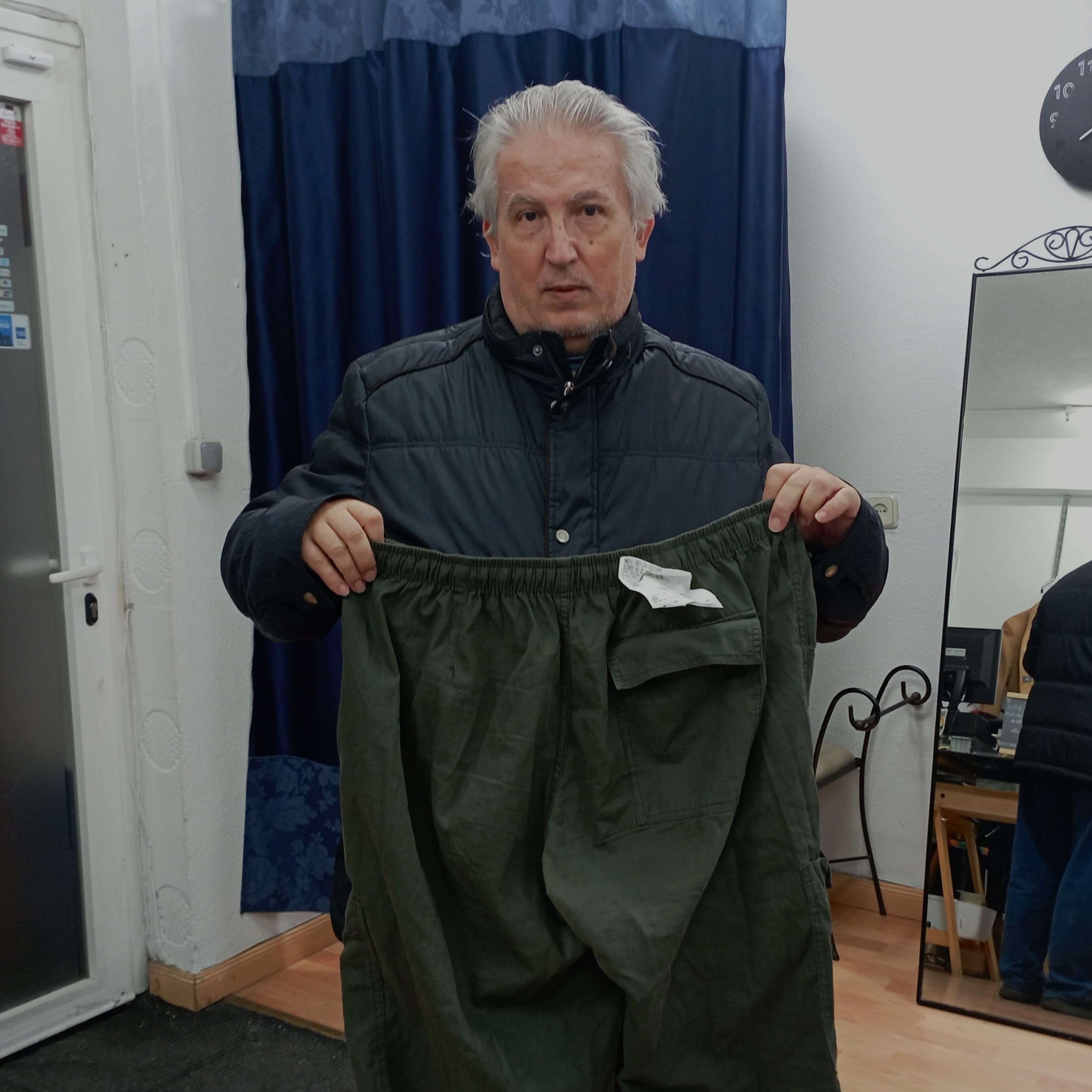 Caballero sosteniendo su pantalón recién tallado